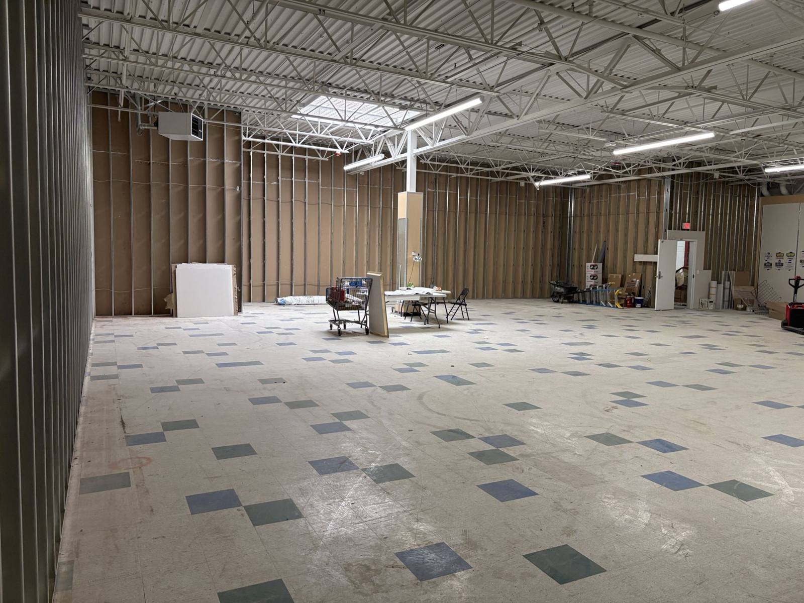 Open interior of the available space at 1261 N. Azusa Ave, Covina, with skylight and steel trusses